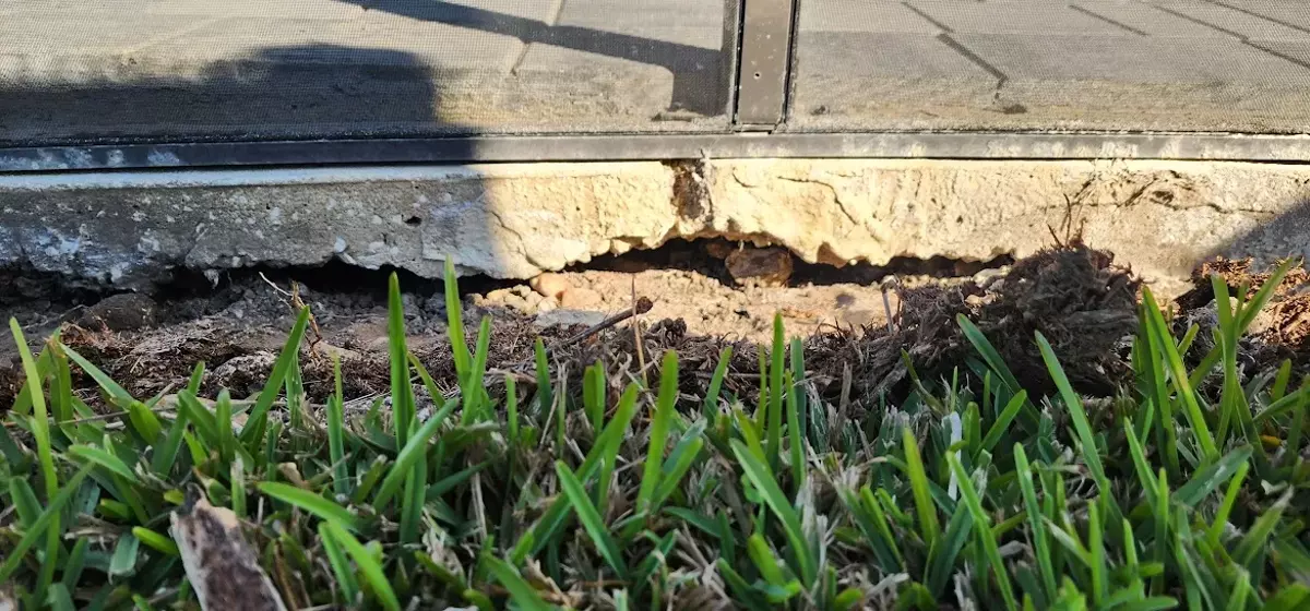 Empty void beneath a Central Florida pool deck where supporting soil washed away