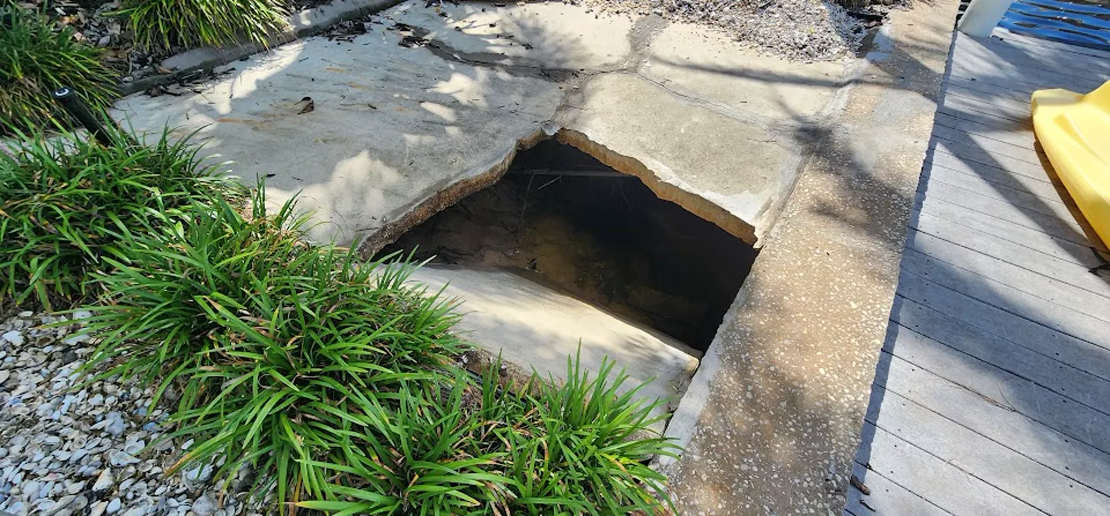 Large void beneath a concrete slab where supporting soil has washed away